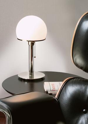 Wagenfeld war 24 Jahre alt, als er als Geselle in der Bauhaus Werkstatt in Weimar aufgenommen wurde. Hier entwarf er das erste Modell dieser Leuchte nach einer von Maholy-Nagy gestellten Aufgabe. Wie Wagenfeld sagte, sollten die Bauhaus-Entwürfe Industrieprodukte sein und auch so aussehen. Tatsächlich waren sie handgefertigt ...

Und genau so wird die Wagenfeld Tischleuchte WA 24 jetzt nach Originalangaben in den Maßen und Material gefertigt. Alle Leuchten sind fortlaufend unter dem Boden nummeriert und tragen die Bauhaus und TECNOLUMEN Zeichen. Der „Bauhaus Leuchte“ wurde nachgewiesen, dass Wagenfelds Leuchte ein Meisterwerk ist, dass sowohl die Bauhaus Philosophie sowie TECNOLUMENs Hingabe für Bauhaus Design veranschaulicht.

TECNOLUMEN produziert 4 verschiedene Versionen dieser Leuchte, alle authentische Entwürfe von Wagenfeld.

Die Bauhaus Leuchte war und wird sehr oft kopiert und gefälscht. Um über Original und Fälschung von Wagenfelds Entwurf sicher zu sein, können Sie hier alles über die authentische und autorisierte Edition nachlesen.

Seit 1986 ist sie auch im Shop des MoMA, New York erhältlich.

Details:
Material: Metall vernickelt, Glasschirm opalüberfangen
Maße: 36 cm (Höhe), 16 cm (Ø Fuß), 18 cm (Ø Kopf)

Einzige urheberrechtlich geschützte und von Prof. Wilhelm Wagenfeld autorisierte Reedition.

Jede Leuchte ist fortlaufend nummeriert und trägt das Signet TECNOLUMEN/BAUHAUS.

Empfohlenes Leuchtmittel: LED Lampe 7 W, matt

---
UrhG §§ 2, 3, 8, 23, 24 – „Bauhaus-Glasleuchte“ Urheber der „Bauhaus-Glasleuchte“, charakterisiert vor allem durch eine runde gläserne Fußplatte, einen gläsernen Schaft, in dessen Innerem ein Metallrohr die elektrische Schnur verbirgt, und einen weißen fast halbkugelförmigen Glasschirm, der die Birne als Lichtquelle verbirgt, ist im Rechtssinne allein Wilhelm Wagenfeld.
OLG Hamburg, Urt.v.4.3.1999 – 3 U169/98
---